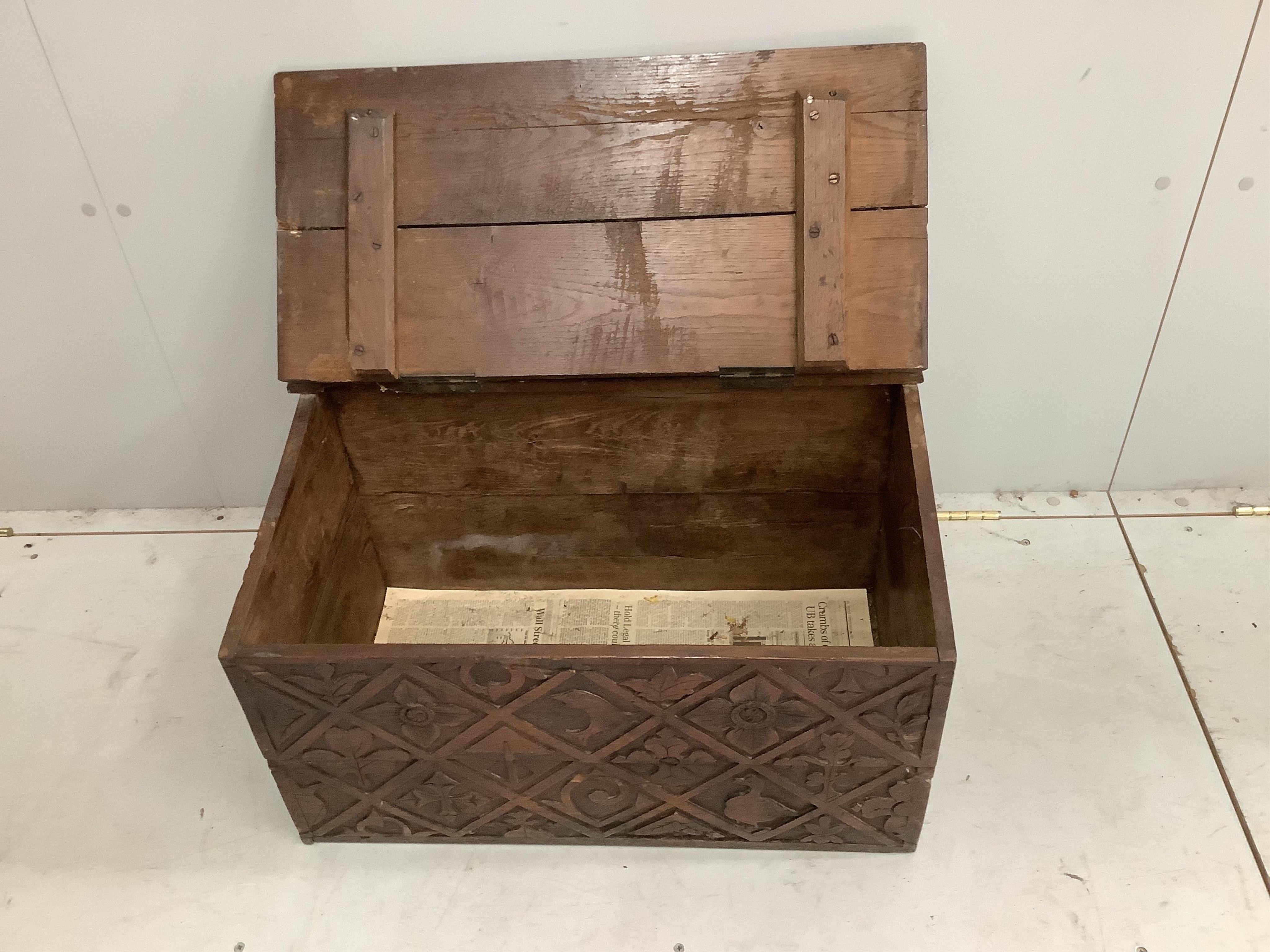 An early 20th century carved oak log bin, width 66cm, height 38cm. Condition - fair